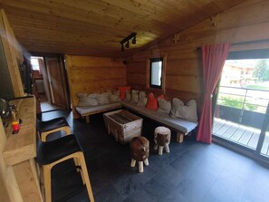 En stuga med träinredning, en träbänk, en soffa och ett litet bord.