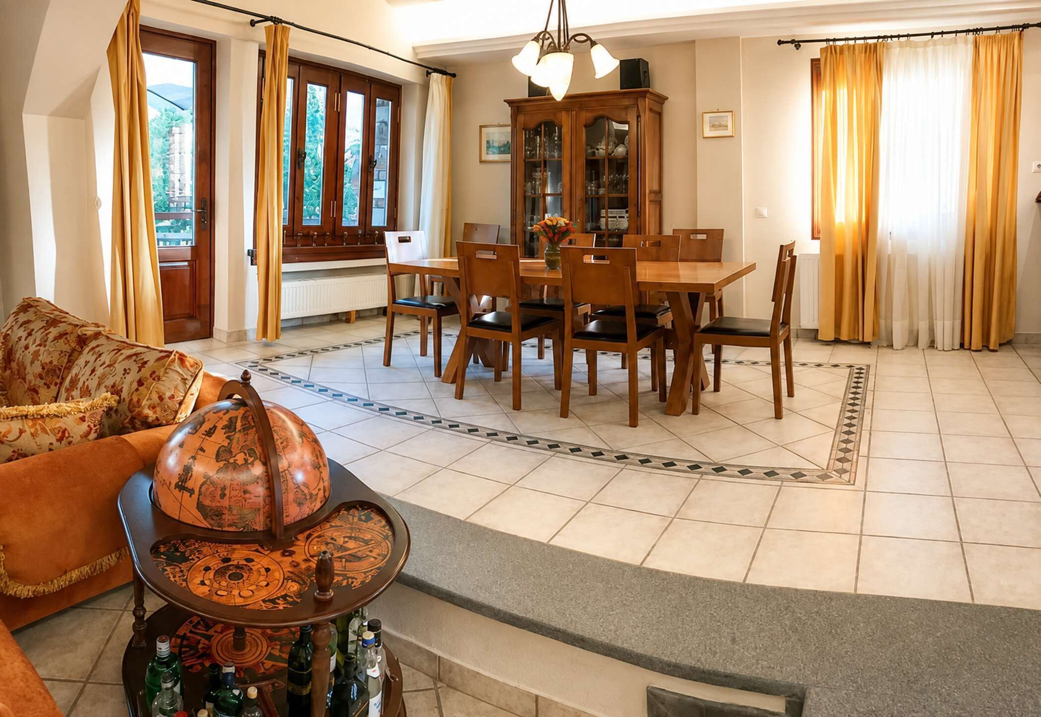 A spacious living room with a dining area, large windows, and a view of the outdoors.