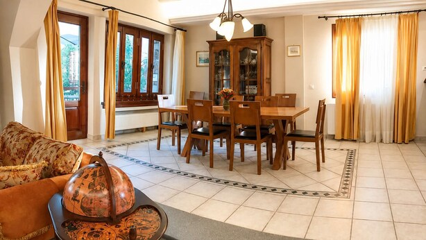 A spacious living room with a dining area, large windows, and a view of the outdoors. - Mountain Breeze Sanctuary with View near Volos (Alli Meria)