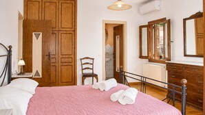 A bedroom with a bed, a chair, a dresser, and a mirror. - Mountain Breeze Sanctuary with View near Volos (Alli Meria)