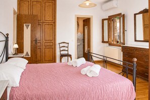 A bedroom with a bed, a chair, a dresser, and a mirror. - Mountain Breeze Sanctuary with View near Volos (Alli Meria)