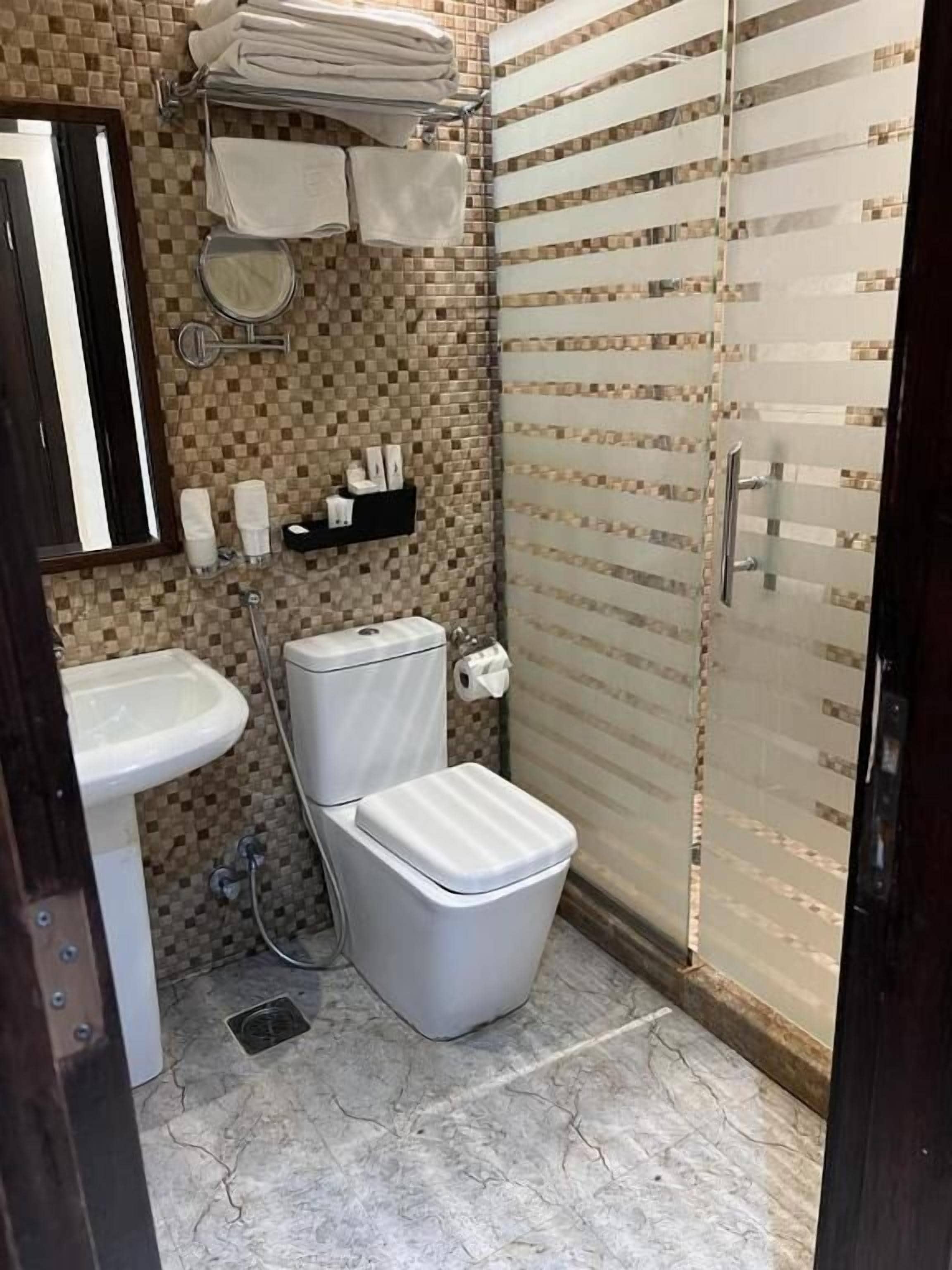 Een badkamer met een wastafel, toilet en douche.