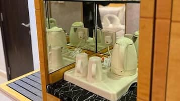 A glass-fronted cabinet with water bottles and a coffee maker.