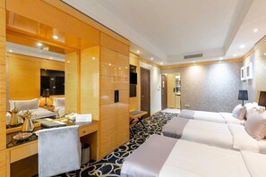 Una habitación de hotel con una cama grande, un escritorio con una silla, un espejo y un armario.
