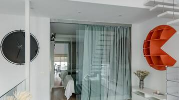 Een modern interieur met een trap, een ronde klok en een opvallende oranje plank.