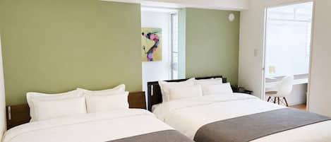 A hotel room with two beds, a desk, and a chair.