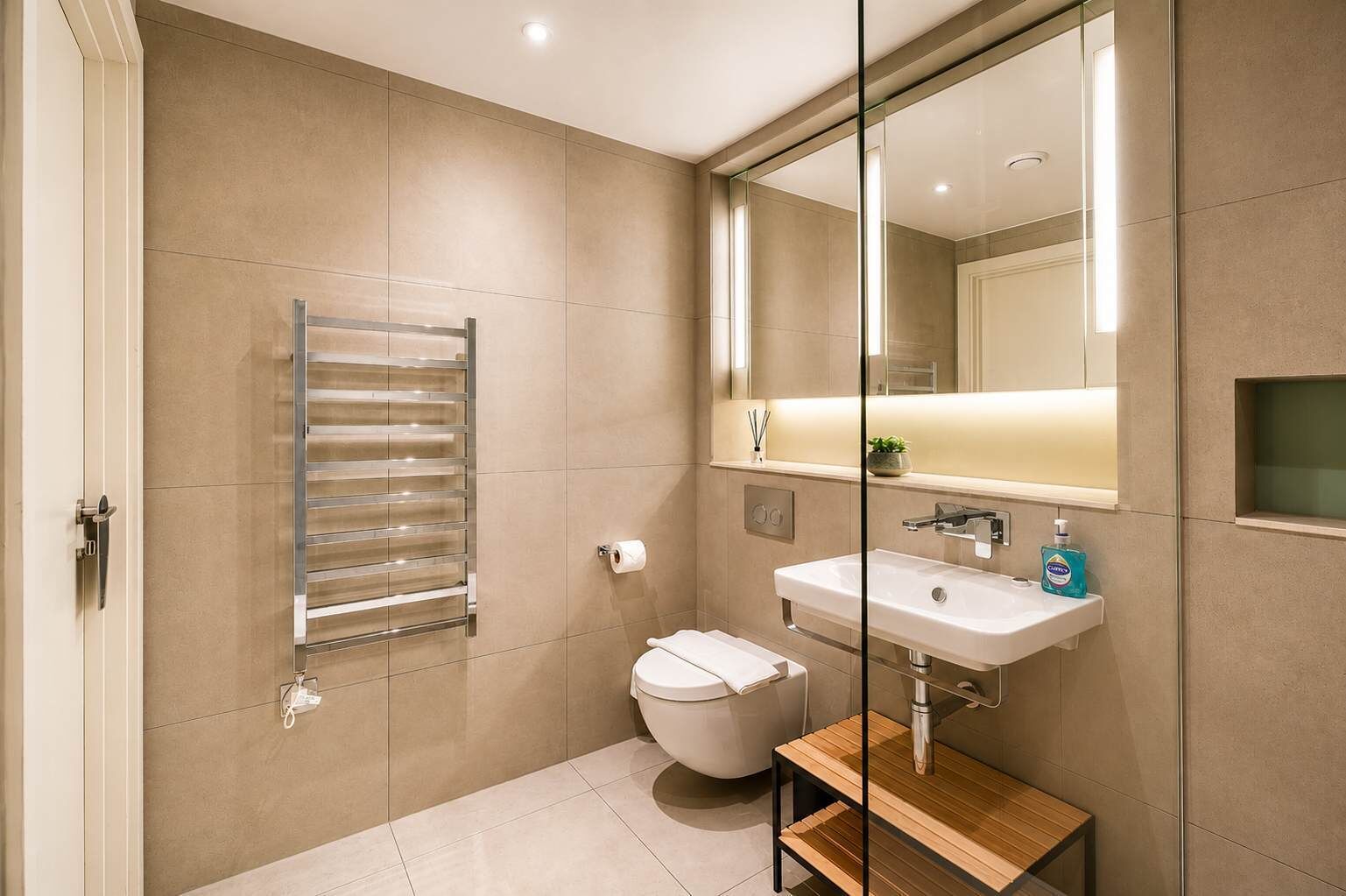 Een moderne badkamer met toilet, wastafel en handdoekhouder.