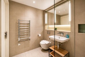 A modern bathroom with a toilet, sink, and towel rack. - Modern Studio by Stay With Us (Salford)