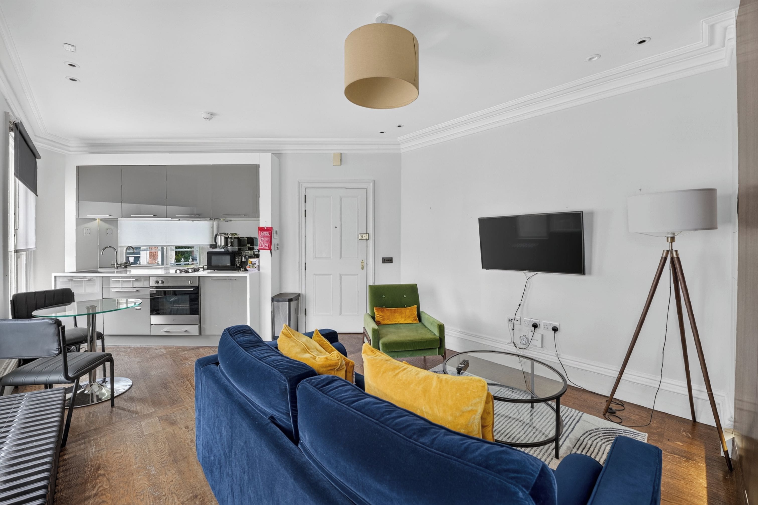 A modern living room with a blue sofa, a green armchair, and a round coffee table.
