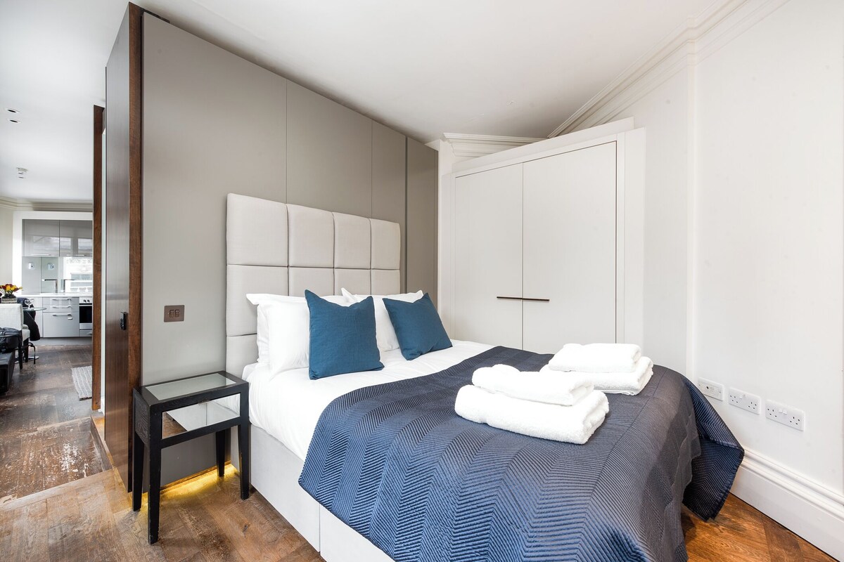 Ein modernes Schlafzimmer mit Bett, Nachttisch und Kleiderschrank.