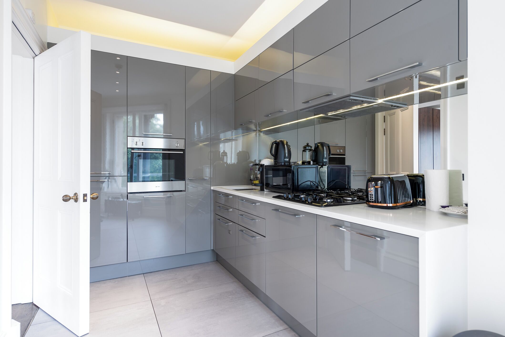 A modern kitchen with a built-in oven, microwave, and gas stove.