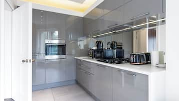 A modern kitchen with a built-in oven, microwave, and gas stove.