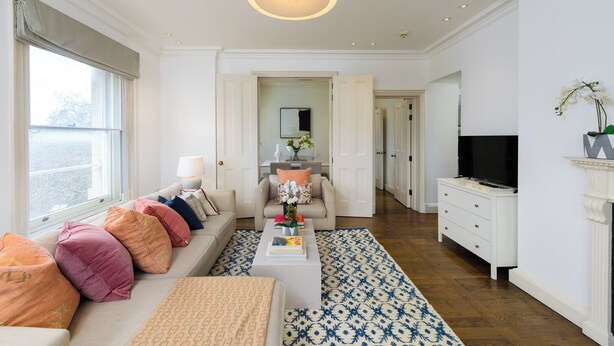 Ein zeitgemäßes Wohnzimmer mit Sofa, Couchtisch und Fernseher.