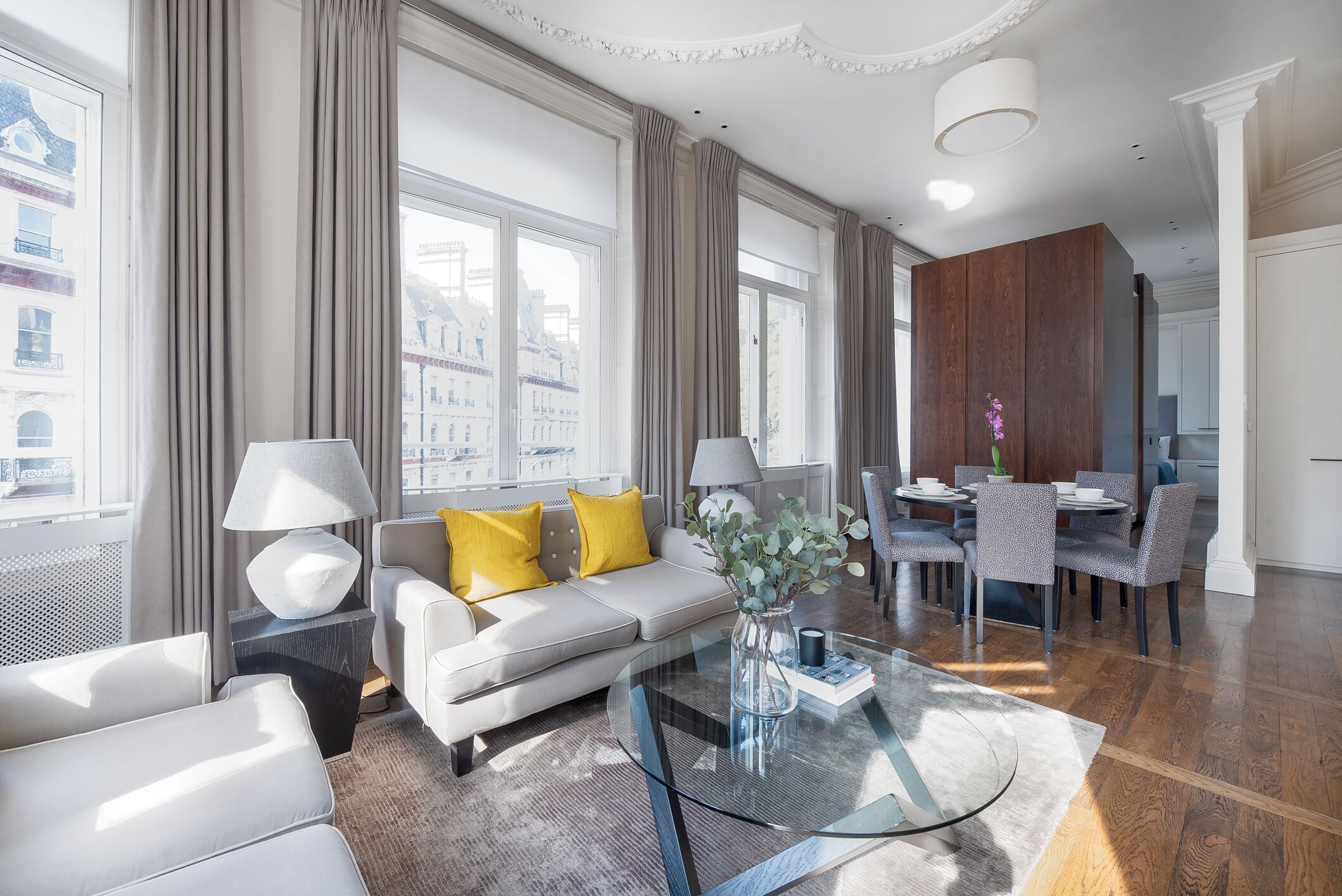 A modern living room with a sofa, coffee table, and dining area.