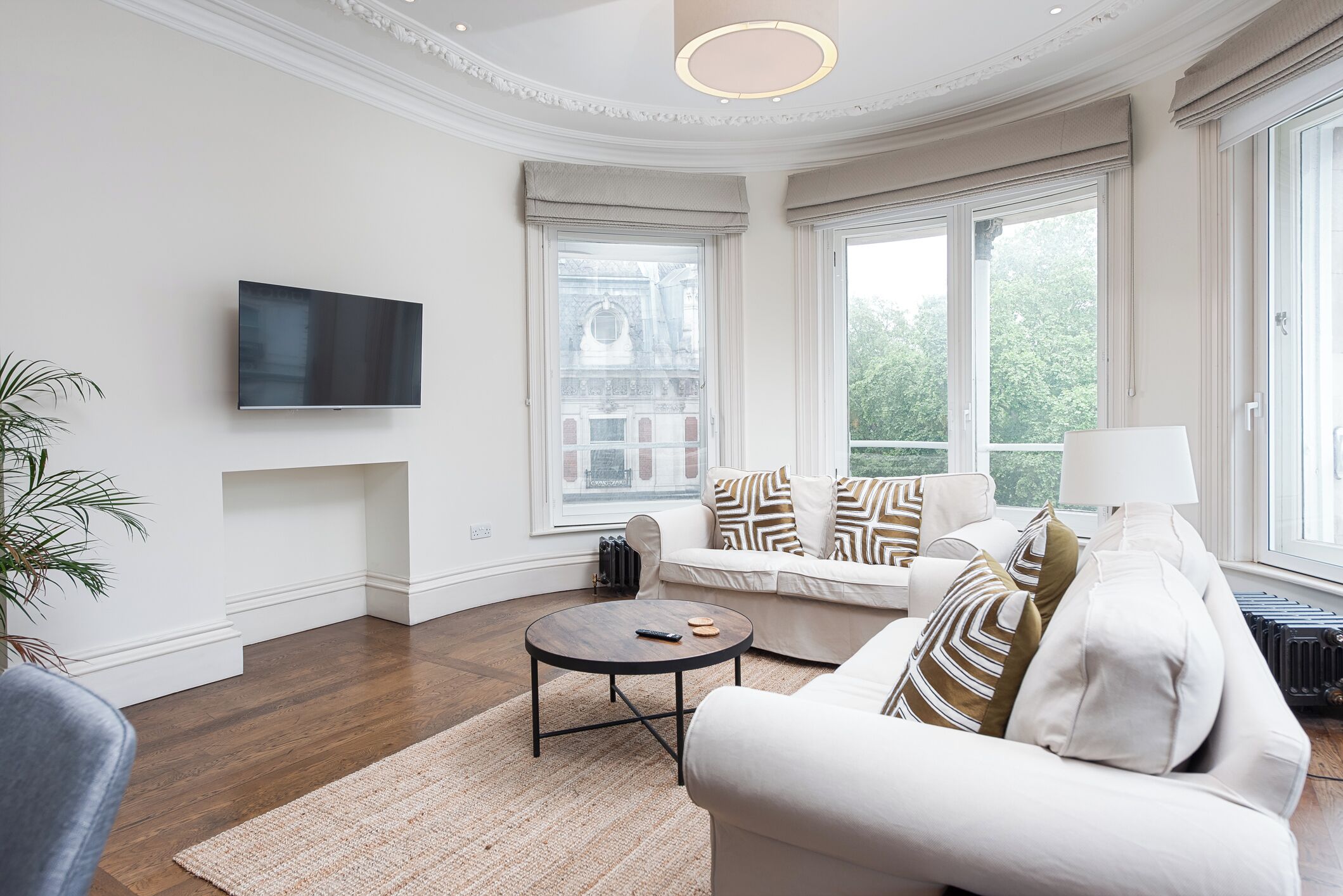 Un salon moderne avec un canapé, une table basse et un téléviseur fixé au mur.