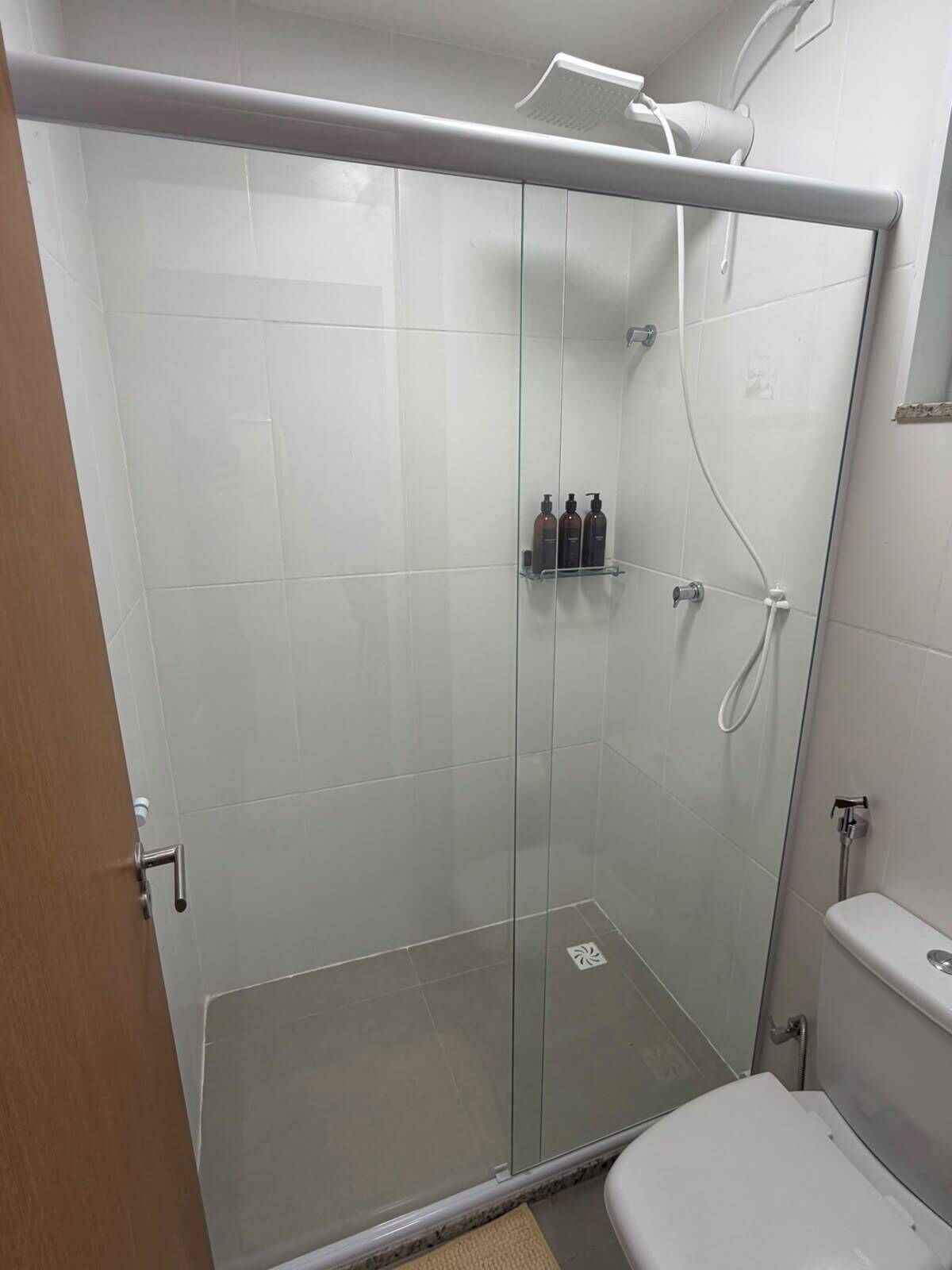 Eine Duschkabine mit Toilette und Handtuchhalter.