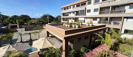 A multi-story building with outdoor seating and a swimming pool.
