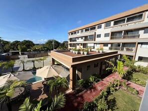 Un edificio a più piani con posti a sedere all'aperto e una piscina.