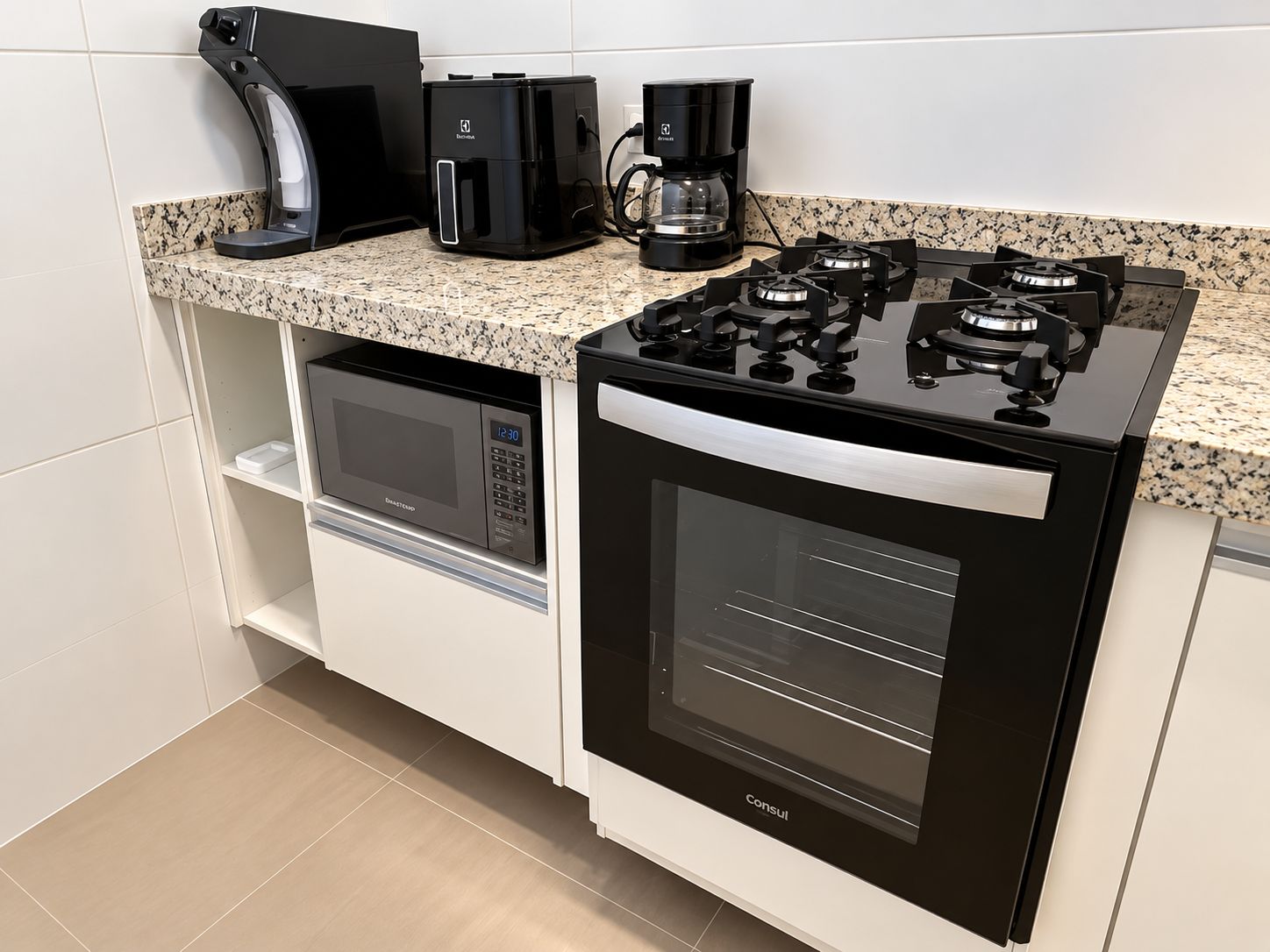 A compact kitchen with a built-in microwave, oven, and gas stove.