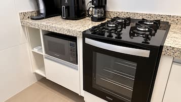 Una cocina compacta con microondas, horno y cocina a gas integrados.