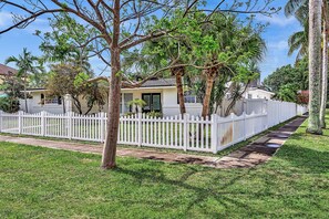 A residential property with a white picket fence, a lawn, and a house with a green door. - Hollywood Hills Oasis Pool 7BR Retreat (Hollywood)