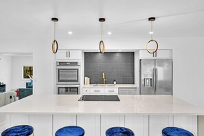 A modern kitchen with a central island, stainless steel appliances, and pendant lighting. - Hollywood Hills Oasis Pool 7BR Retreat (Hollywood)