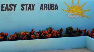 A wall with the text "EASY STAY ARUBA" and a sun emblem.