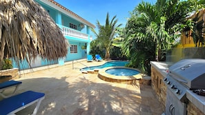 Ein Garten mit Swimmingpool, Whirlpool und Grill.