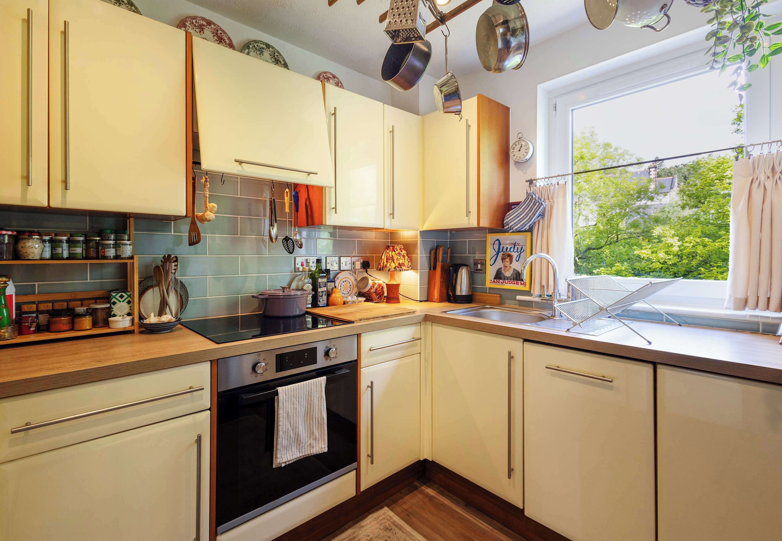 A kitchen with a stove, oven, sink, and various utensils.
