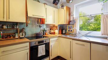 A kitchen with a stove, oven, sink, and various utensils.