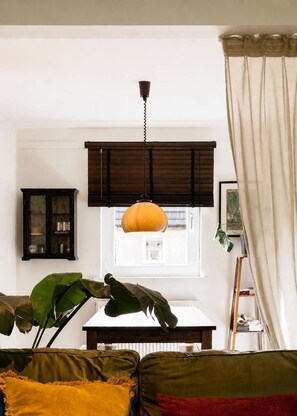 A room with a window, a hanging lamp, a cabinet, and a plant. - River View Home in Stockbridge with Parking and Study (Edinburgh)