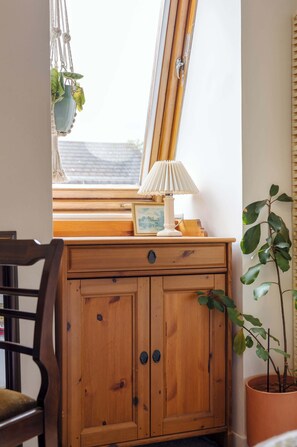 A wooden cabinet with a window above it, a lamp, and a framed picture on the windowsill. - River View Home in Stockbridge with Parking and Study (Edinburgh)