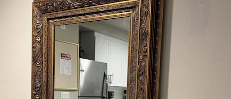 A mirror with an ornate frame mounted on a wall.