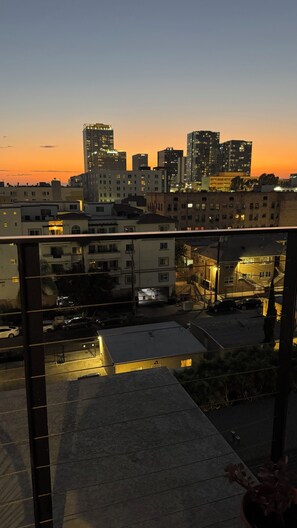 A cityscape at dusk with modern buildings and a parking area.