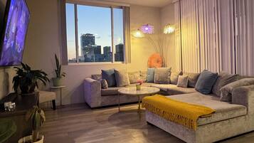 Una sala moderna con un sofá, una mesa de centro y un televisor montado en la pared.