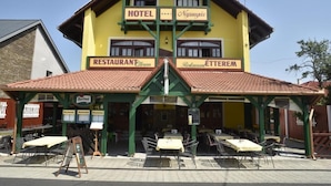 Un edificio amarillo con un cartel que indica que es un hotel y restaurante.