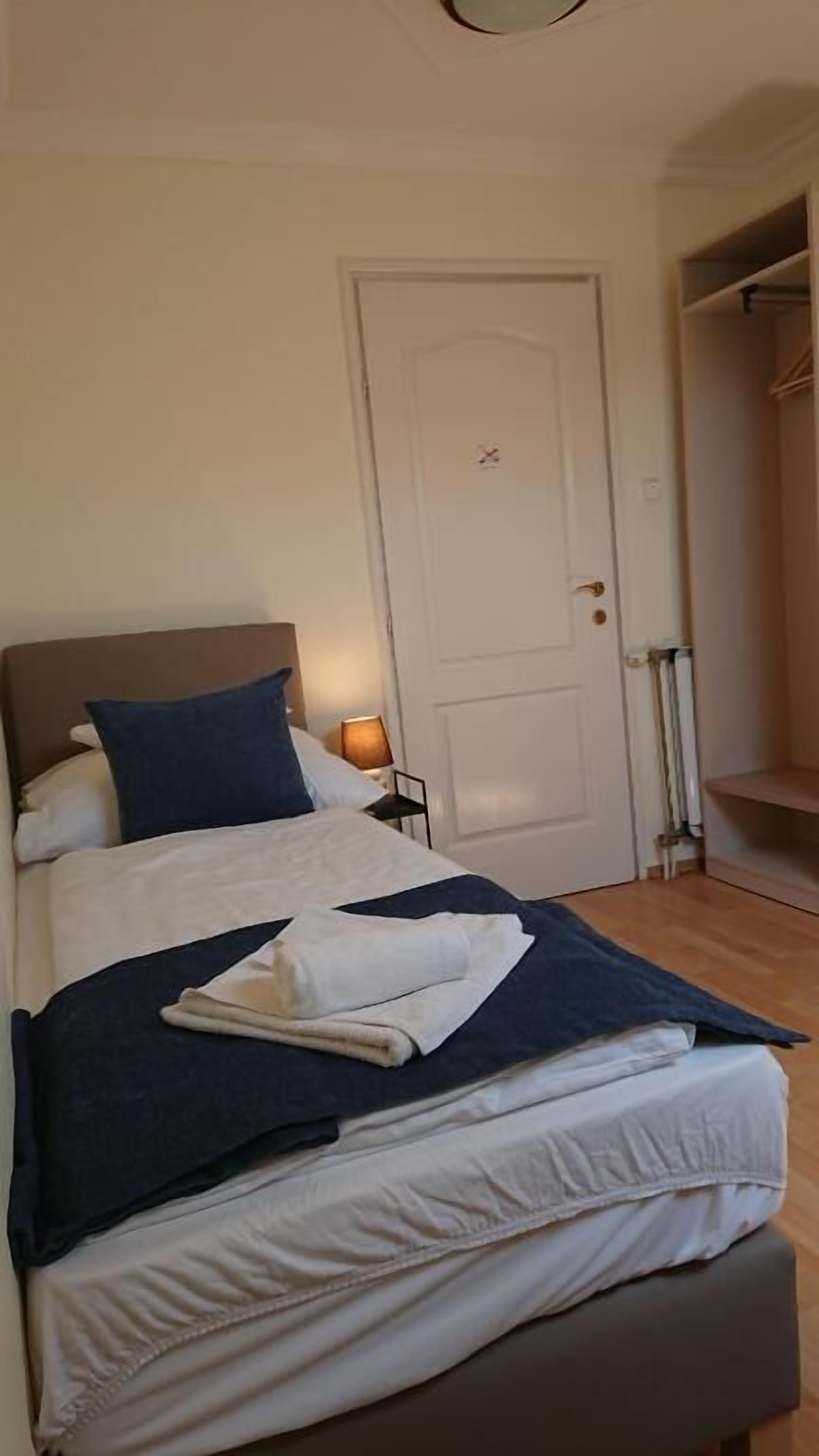 Ein Hotelzimmer mit einem Bett, einem Nachttisch und einem Kleiderschrank.