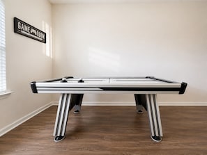 Ett biljardbord i ett rum där det hänger en skylt med texten ”SPELRUM” på väggen.
