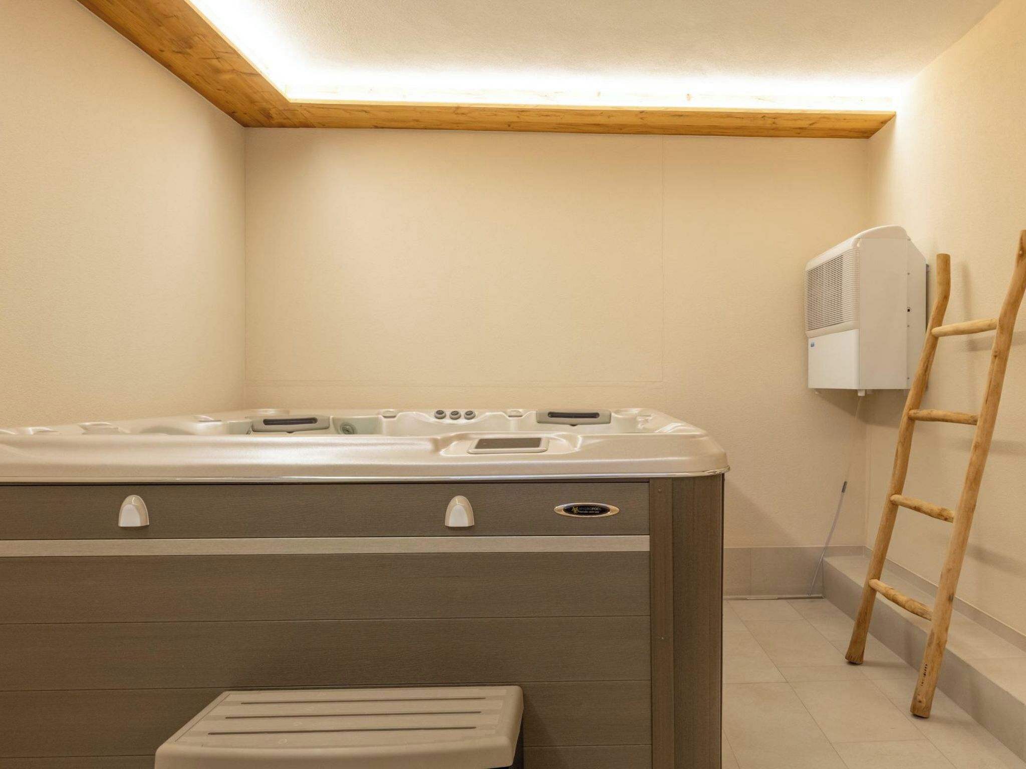 Un bagno con soffitto in legno, una vasca, una doccia e una scala.