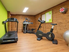 Ein Fitnessstudio mit Laufbändern, Crosstrainern und Ergometer.