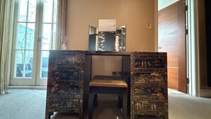 A room with a desk featuring intricate carvings, a chair, a window with curtains, and a door. - Artsy and Spacious 2BDR Flat in Central London (Greater London)
