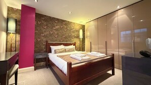 A modern bedroom with a wooden bed, a desk, and a wardrobe. - Artsy and Spacious 2BDR Flat in Central London (Greater London)