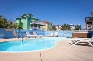 Ein Schwimmbecken mit Liegestühlen und einer Holzterrasse.