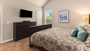 A bedroom with a bed, dresser, TV, and artwork. - NEW Stunning River Access, Retreat on Guadalupe River, Tubing, Family Fun Amenities, Tubing Fun (New Braunfels)