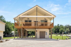 Ein zweistöckiges Haus mit Balkon, Garage und einer Terrassenfläche.