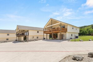 A two-story building with a covered patio and a balcony. - NEW Stunning River Access, Retreat on Guadalupe River, Tubing, Family Fun Amenities, Tubing Fun (New Braunfels)