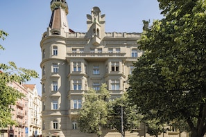 Ein mehrgeschossiges Gebäude mit einem markanten Turm und einem Balkon.