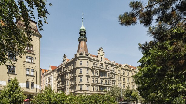 Ein historisches Gebäude mit einem markanten Turm und zahlreichen Fenstern.
