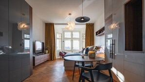 Ein zeitgemäßer Wohnbereich mit Essplatz, Küche und Sitzgelegenheit am Fenster.