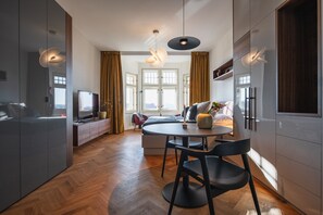 Ein zeitgemäßer Wohnbereich mit Essplatz, Küche und Sitzgelegenheit am Fenster.